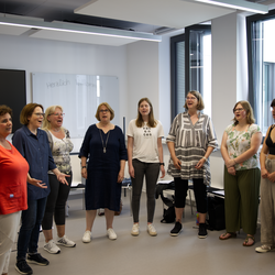 The university choir in a circle in the rehearsal room