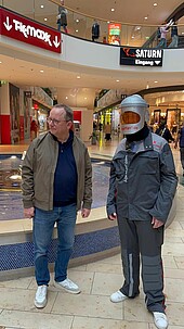 Man in age simulation suit in Rhein-Galerie