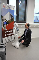 Minister Hoch and robots look at each other