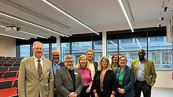 Gruppenbild beim Rundgang auf dem Campus, hier im Atrium des Neubaus