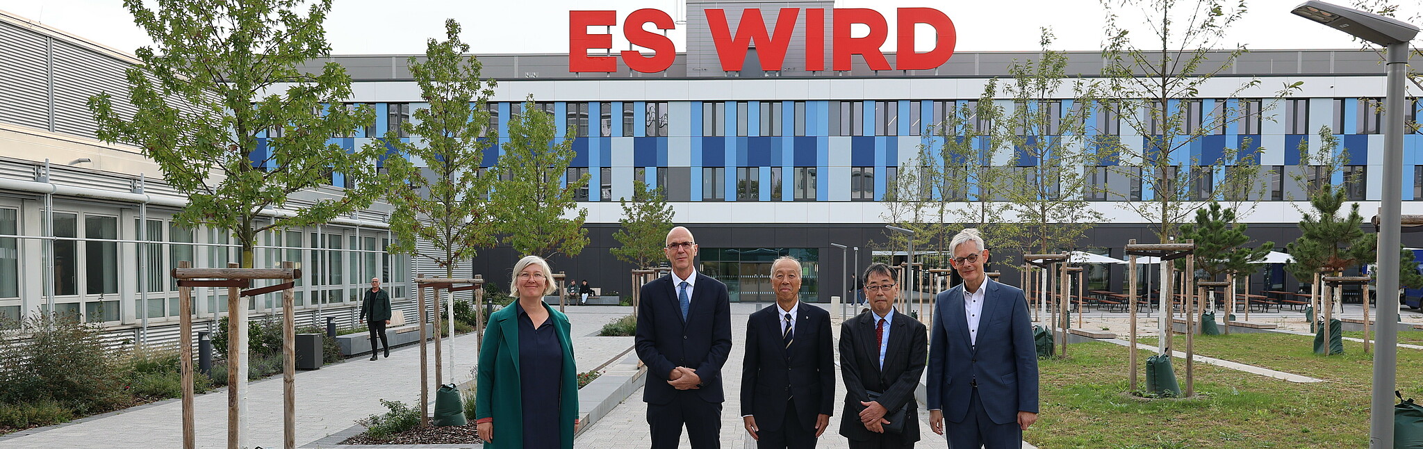 Gruppenfoto vor dem Neubau der Hochschule