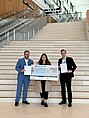 Three students with a prize check