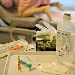 A side table with a treatment set, latex gloves and disinfectant wipes.