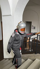 Woman in age simulation suit climbing stairs